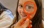 jeune fille avec une loupe près de l'oeil