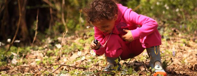 Fillette observant les feuilles avec une loupe