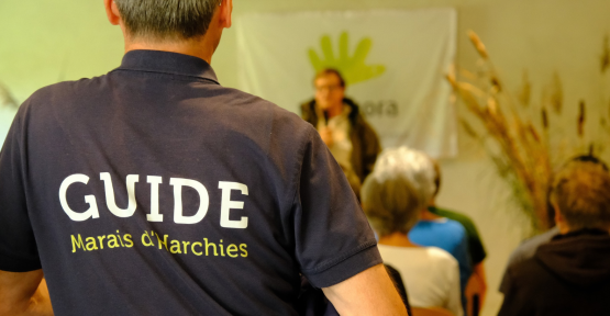 Vue sur une personne portant un t-shirt "Guide Marais Harchies", lors du discours d'ouverture de la fête des 70 ans de protection des marais d'Harchies