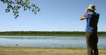 Paysage étang eau observateur avec des jumelles ciel bleu